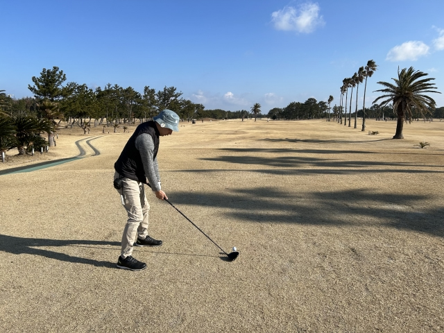 リゾート地でゴルフプレイする男性